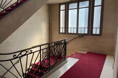 Espace intérieur lumineux avec un studio photo, canapé violet, table en bois et décoration moderne.