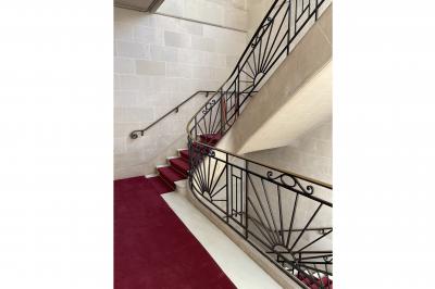 Espace intérieur lumineux avec un studio photo, canapé violet, table en bois et décoration moderne.