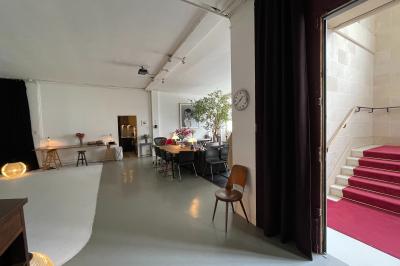 Espace intérieur lumineux avec un studio photo, canapé violet, table en bois et décoration moderne.