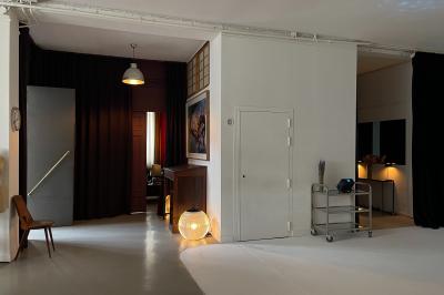 Espace intérieur lumineux avec un studio photo, canapé violet, table en bois et décoration moderne.