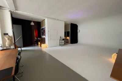 Espace intérieur lumineux avec un studio photo, canapé violet, table en bois et décoration moderne.