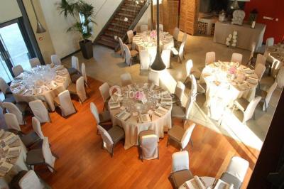 Un groupe de personnes joue au ballon sur une pelouse devant un grand bâtiment ancien sous un ciel dégagé.