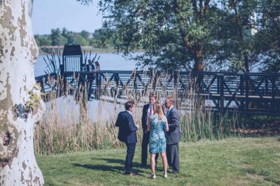 Un groupe de personnes joue au ballon sur une pelouse devant un grand bâtiment ancien sous un ciel dégagé.