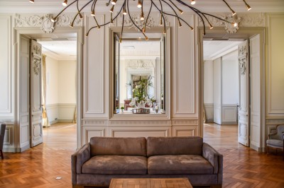 Montgolfière en cours de gonflage sur une pelouse, avec un manoir en arrière-plan et des arbres environnants.