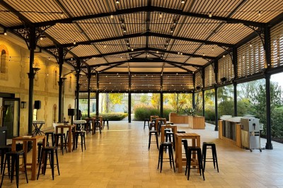 Montgolfière en cours de gonflage sur une pelouse, avec un manoir en arrière-plan et des arbres environnants.