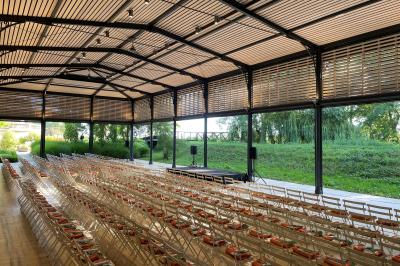 Un groupe de personnes joue au ballon sur une pelouse devant un grand bâtiment ancien sous un ciel dégagé.