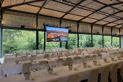 Montgolfière en cours de gonflage sur une pelouse, avec un manoir en arrière-plan et des arbres environnants.