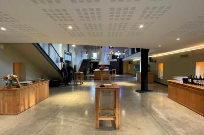 Un groupe de personnes joue au ballon sur une pelouse devant un grand bâtiment ancien sous un ciel dégagé.