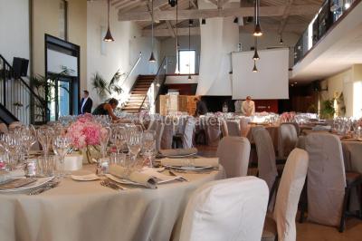 Un groupe de personnes joue au ballon sur une pelouse devant un grand bâtiment ancien sous un ciel dégagé.