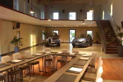 Un groupe de personnes joue au ballon sur une pelouse devant un grand bâtiment ancien sous un ciel dégagé.