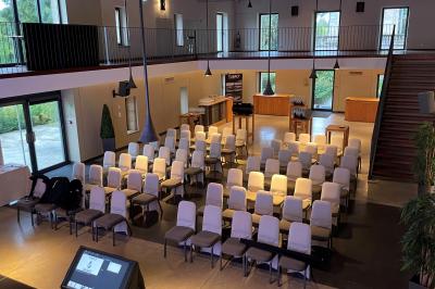 Un groupe de personnes joue au ballon sur une pelouse devant un grand bâtiment ancien sous un ciel dégagé.