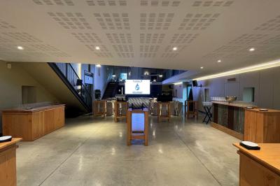 Un groupe de personnes joue au ballon sur une pelouse devant un grand bâtiment ancien sous un ciel dégagé.