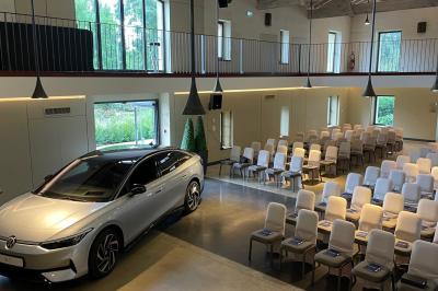 Un groupe de personnes joue au ballon sur une pelouse devant un grand bâtiment ancien sous un ciel dégagé.
