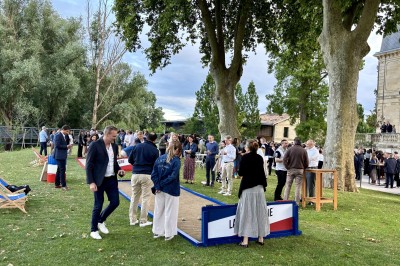 Montgolfière en cours de gonflage sur une pelouse, avec un manoir en arrière-plan et des arbres environnants.