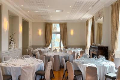 Un groupe de personnes joue au ballon sur une pelouse devant un grand bâtiment ancien sous un ciel dégagé.