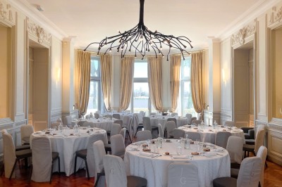 Montgolfière en cours de gonflage sur une pelouse, avec un manoir en arrière-plan et des arbres environnants.