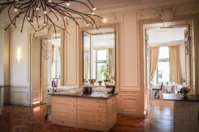 Un groupe de personnes joue au ballon sur une pelouse devant un grand bâtiment ancien sous un ciel dégagé.