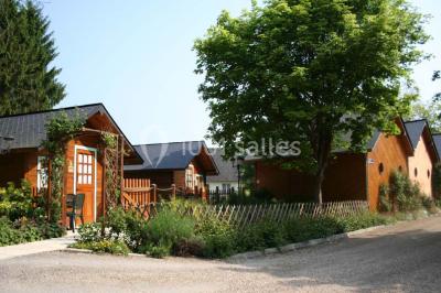 Un jardin avec pelouse, arbres variés et un lampadaire, éclairé par une lumière douce du matin.