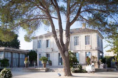 Vue d'une pièce lumineuse avec sol en carreaux anciens, mobilier classique et une chambre attenante avec lit à baldaquin.