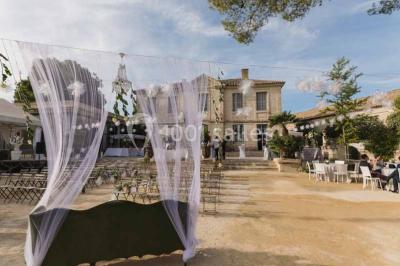 Vue d'une pièce lumineuse avec sol en carreaux anciens, mobilier classique et une chambre attenante avec lit à baldaquin.