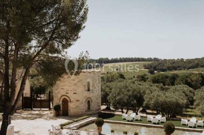 Vue d'une pièce lumineuse avec sol en carreaux anciens, mobilier classique et une chambre attenante avec lit à baldaquin.