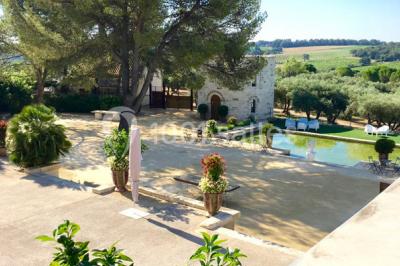 Vue d'une pièce lumineuse avec sol en carreaux anciens, mobilier classique et une chambre attenante avec lit à baldaquin.