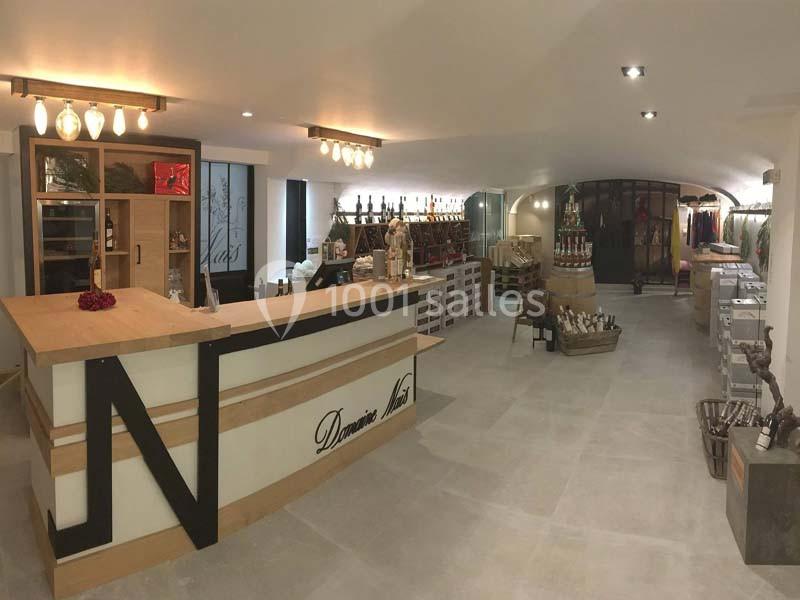 Location salle Rognes (Bouches-du-Rhône) - Domaine Naïs #18 Intérieur d'une boutique avec comptoir en bois, étagères de produits et éclairage moderne.