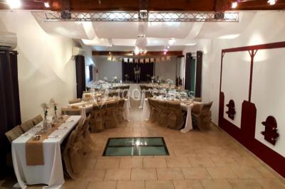 Miniature Location salle Rognes (Bouches-du-Rhône) - Domaine Naïs #8 Terrasse en pierre avec des tonneaux en bois, vue sur un paysage verdoyant et une clôture en fer forgé.