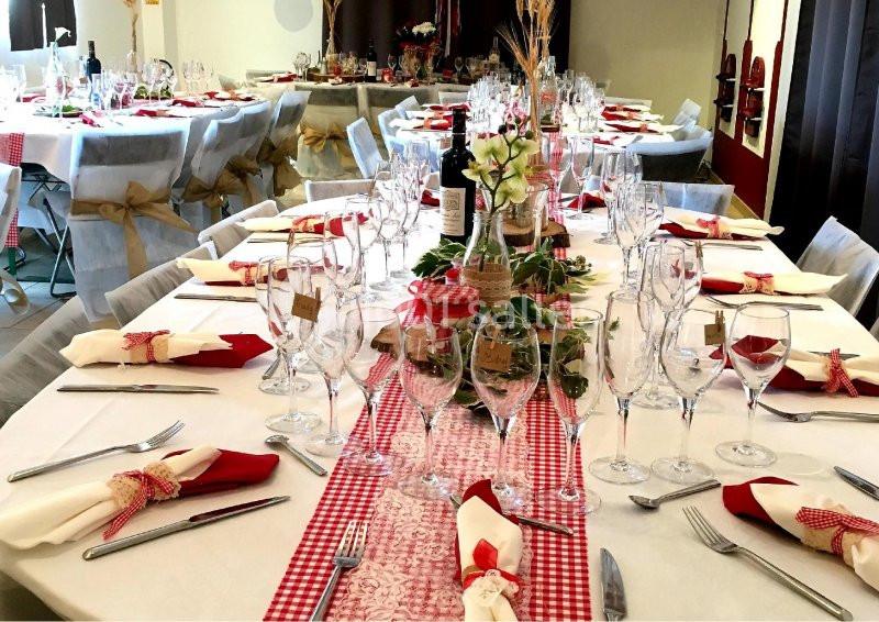Location salle Rognes (Bouches-du-Rhône) - Domaine Naïs #5 Table dressée pour un repas festif avec nappes blanches, chemins de table rouges, verres, couverts et décorations rustiques.