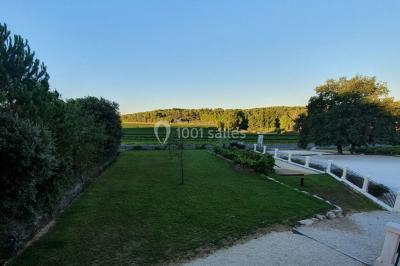 Miniature Location salle Rognes (Bouches-du-Rhône) - Domaine Naïs #4 Terrasse en pierre avec des tonneaux en bois, vue sur un paysage verdoyant et une clôture en fer forgé.