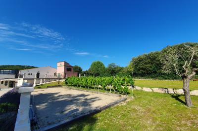 Miniature Location salle Rognes (Bouches-du-Rhône) - Domaine Naïs #22 Terrasse en pierre avec des tonneaux en bois, vue sur un paysage verdoyant et une clôture en fer forgé.