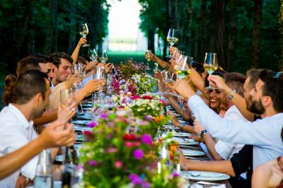 Assortiment de fromages et saumon fumé sur une table avec une bouteille de vin rouge, verres et cheminée en arrière-plan.