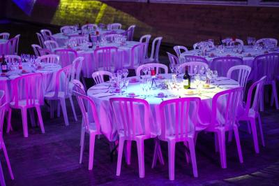 Assortiment de fromages et saumon fumé sur une table avec une bouteille de vin rouge, verres et cheminée en arrière-plan.