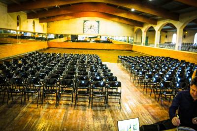 Assortiment de fromages et saumon fumé sur une table avec une bouteille de vin rouge, verres et cheminée en arrière-plan.