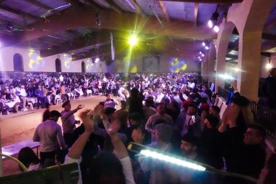 Assortiment de fromages et saumon fumé sur une table avec une bouteille de vin rouge, verres et cheminée en arrière-plan.