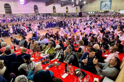 Assortiment de fromages et saumon fumé sur une table avec une bouteille de vin rouge, verres et cheminée en arrière-plan.
