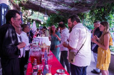 Assortiment de fromages et saumon fumé sur une table avec une bouteille de vin rouge, verres et cheminée en arrière-plan.