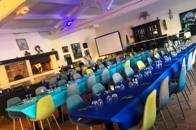 Assortiment de fromages et saumon fumé sur une table avec une bouteille de vin rouge, verres et cheminée en arrière-plan.