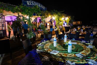 Assortiment de fromages et saumon fumé sur une table avec une bouteille de vin rouge, verres et cheminée en arrière-plan.
