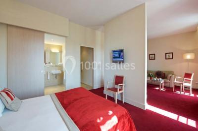 Croupier debout derrière une table de blackjack dans un casino, avec jetons et cartes visibles.