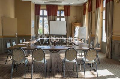 Croupier debout derrière une table de blackjack dans un casino, avec jetons et cartes visibles.