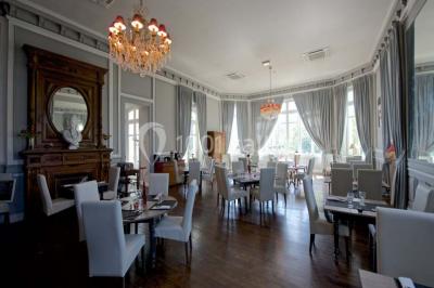 Croupier debout derrière une table de blackjack dans un casino, avec jetons et cartes visibles.