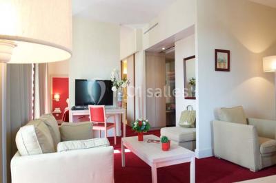 Croupier debout derrière une table de blackjack dans un casino, avec jetons et cartes visibles.