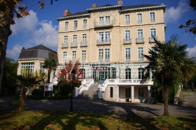 Croupier debout derrière une table de blackjack dans un casino, avec jetons et cartes visibles.