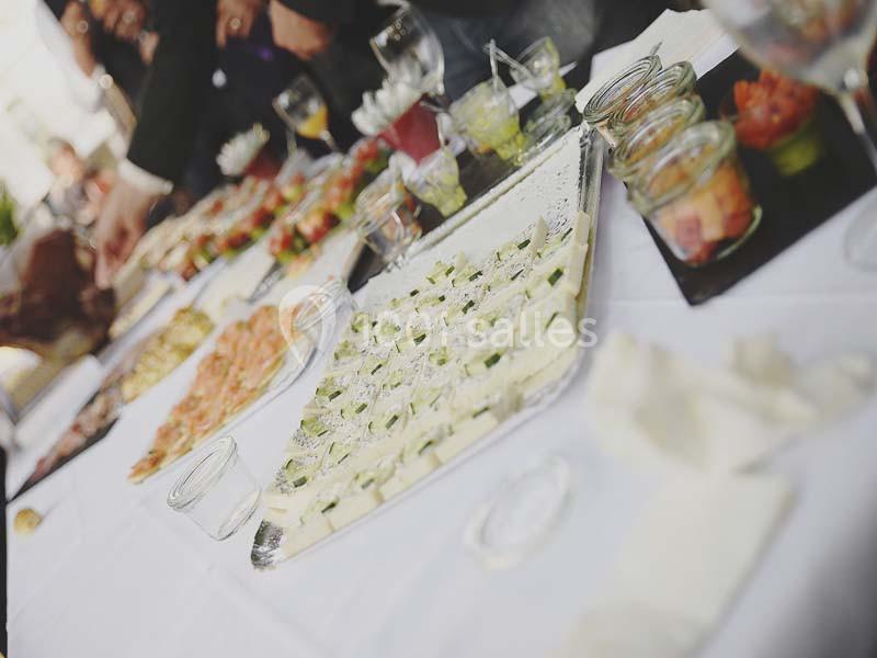 Plateau de bouchées apéritives variées disposé sur une table blanche lors d'un buffet.