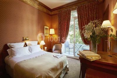 Miniature Location salle Divonne-les-Bains (Ain) - Domaine de Divonne #15 Salle de restaurant élégante avec tables dressées, chaises en bois sculpté et décor floral sur les murs et le sol.