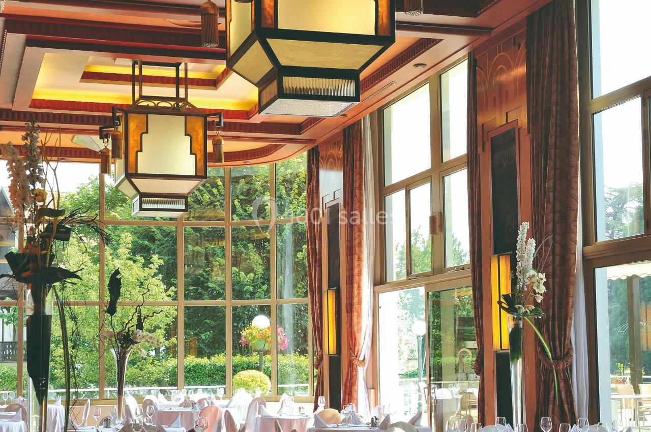 Location salle Divonne-les-Bains (Ain) - Domaine de Divonne #3 Salle de restaurant élégante avec grandes baies vitrées, tables dressées et luminaires suspendus au plafond.