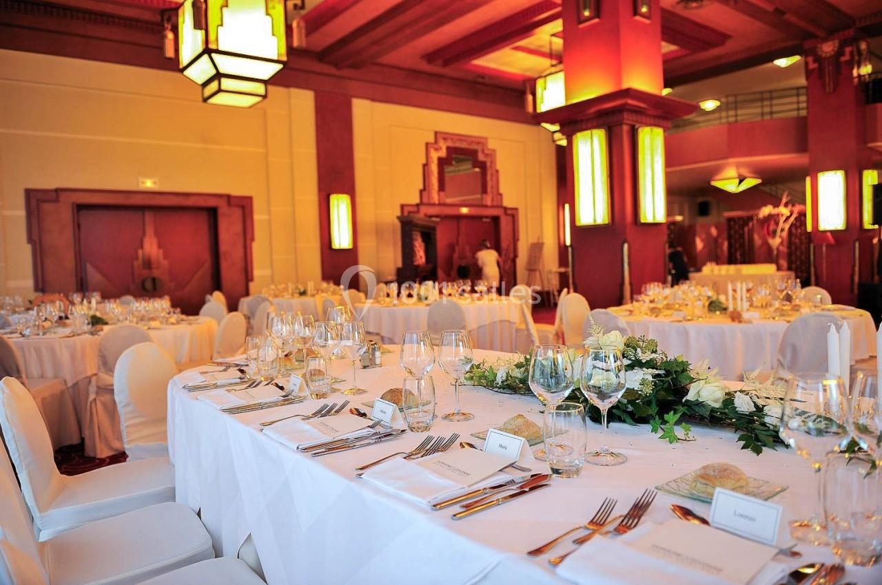 Location salle Divonne-les-Bains (Ain) - Domaine de Divonne #4 Salle de réception élégante avec tables dressées, nappes blanches, verres, couverts et décoration florale.