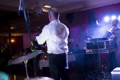 Salle de réception avec scène, piste de danse en bois, moquette rouge et plafond décoré d'une fresque.