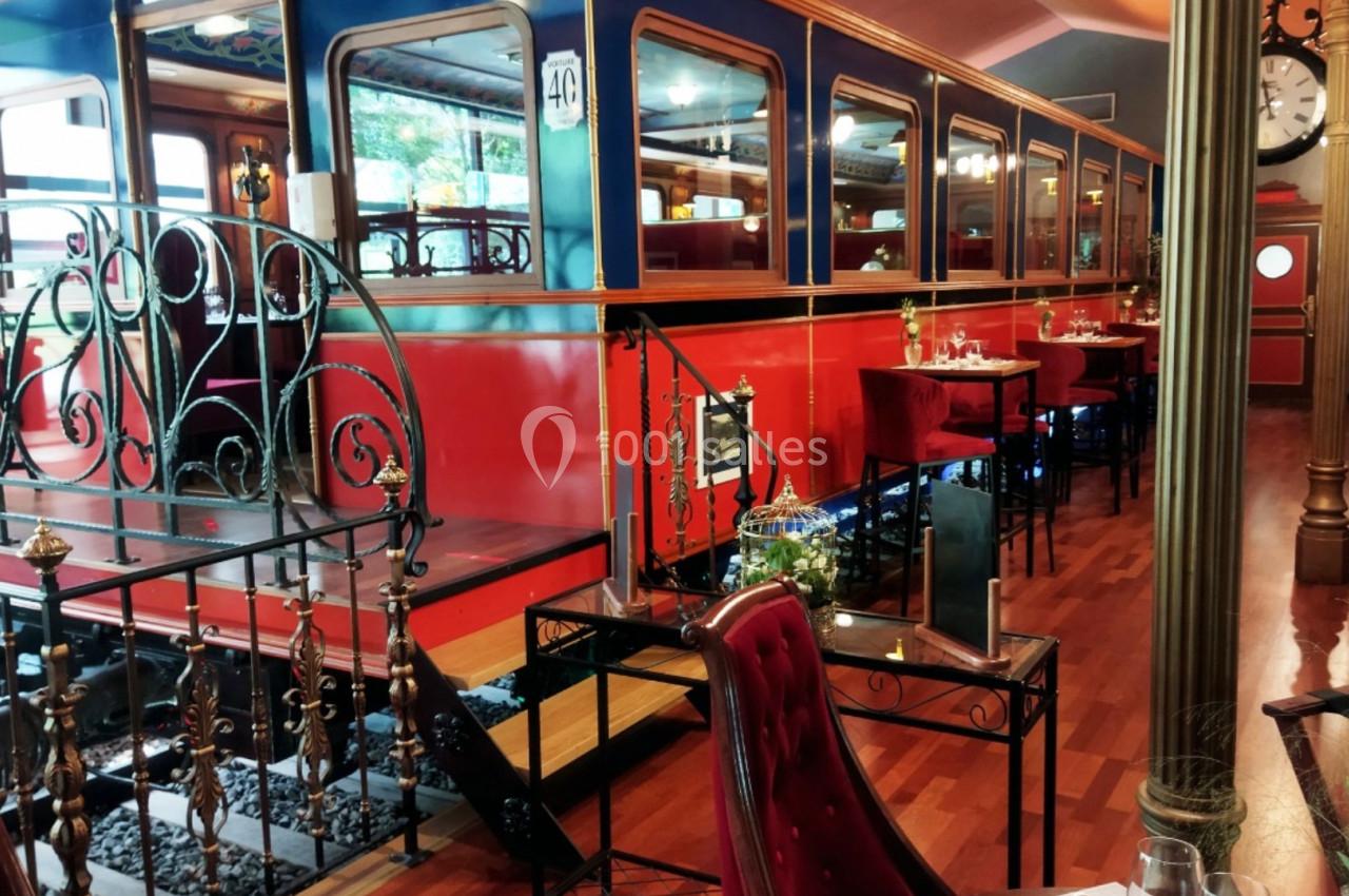 Intérieur d'un restaurant aménagé dans un décor de wagon de train avec tables, chaises et ambiance rétro.